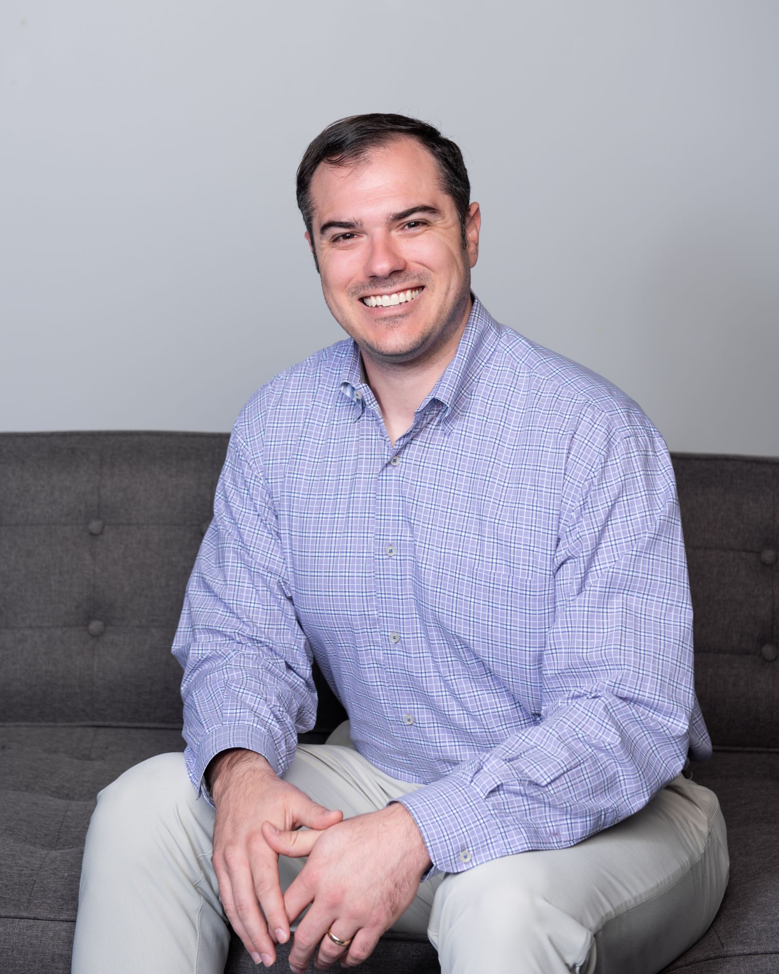Dr. Barry Benton, board-certified orthodontist at Designer Smiles by Benton, smiling in a casual seated setting