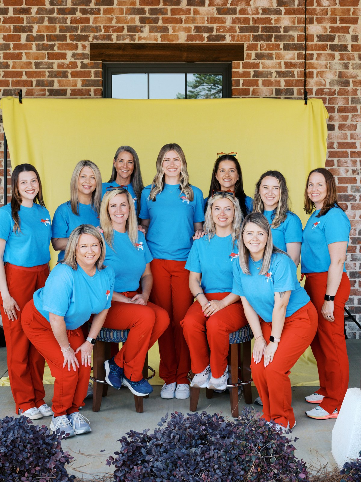 The Designer Smiles by Benton team in Hometown Heroes shirts in front of a yellow backdrop